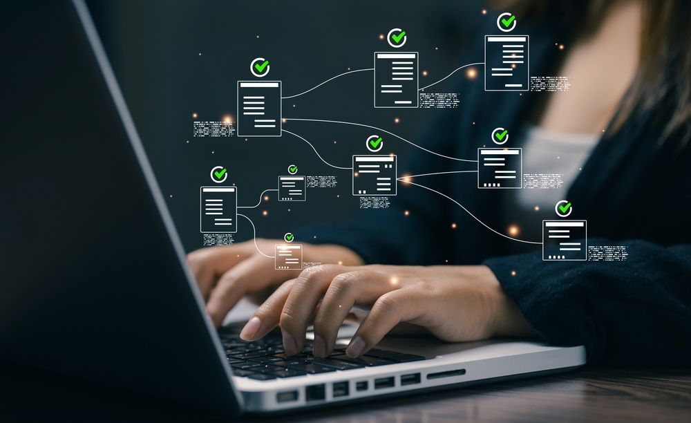 Hands typing on a laptop with floating digital workflow icons over the screen