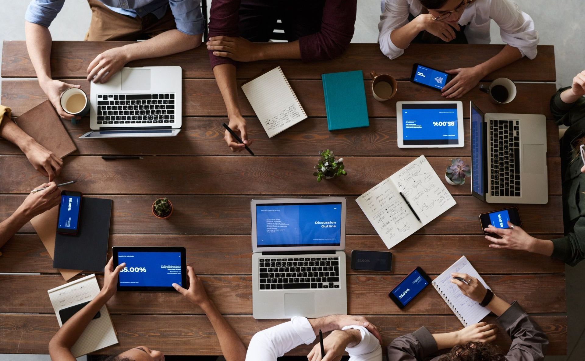 image of perrson gathered around table interacting with computers