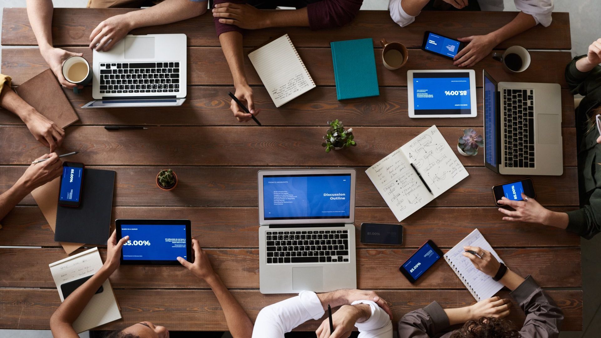 image of perrson gathered around table interacting with computers