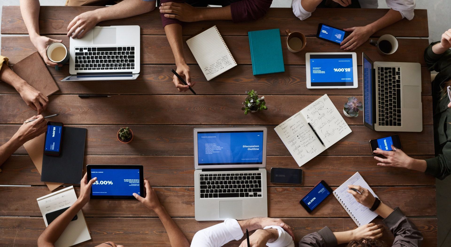 image of people gathered around table interacting with computers