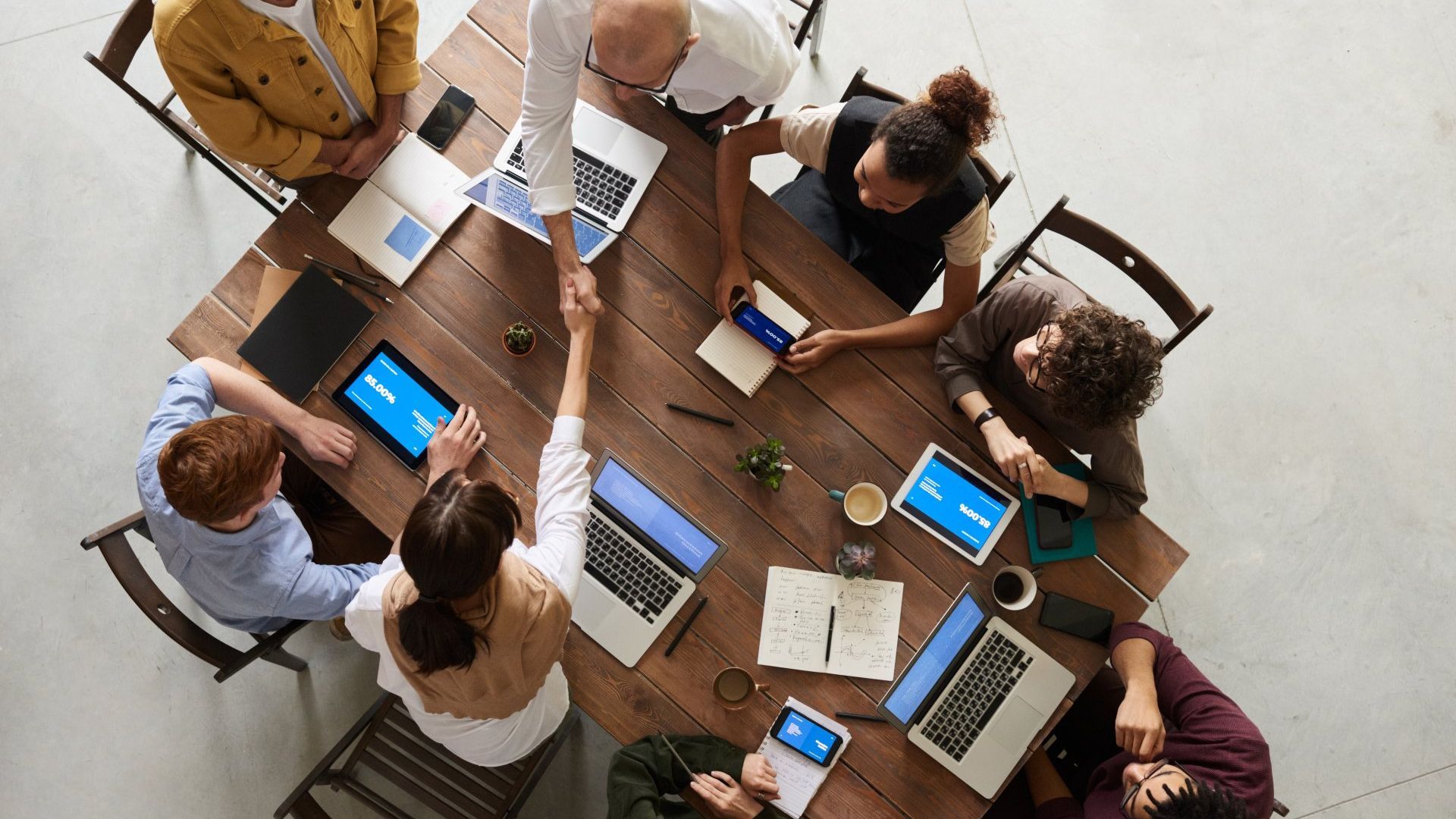 image of perrson gathered around table interacting with computers