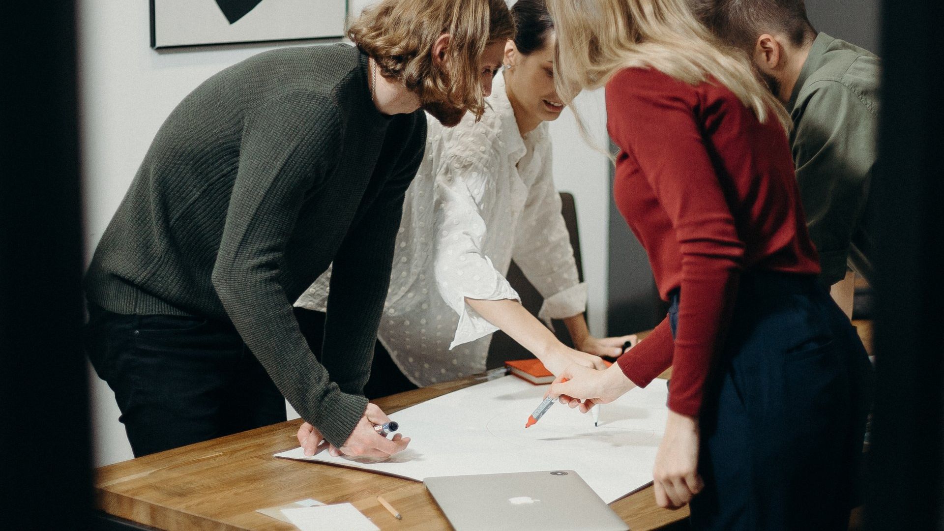 people gathered around a conference room full of documents image
