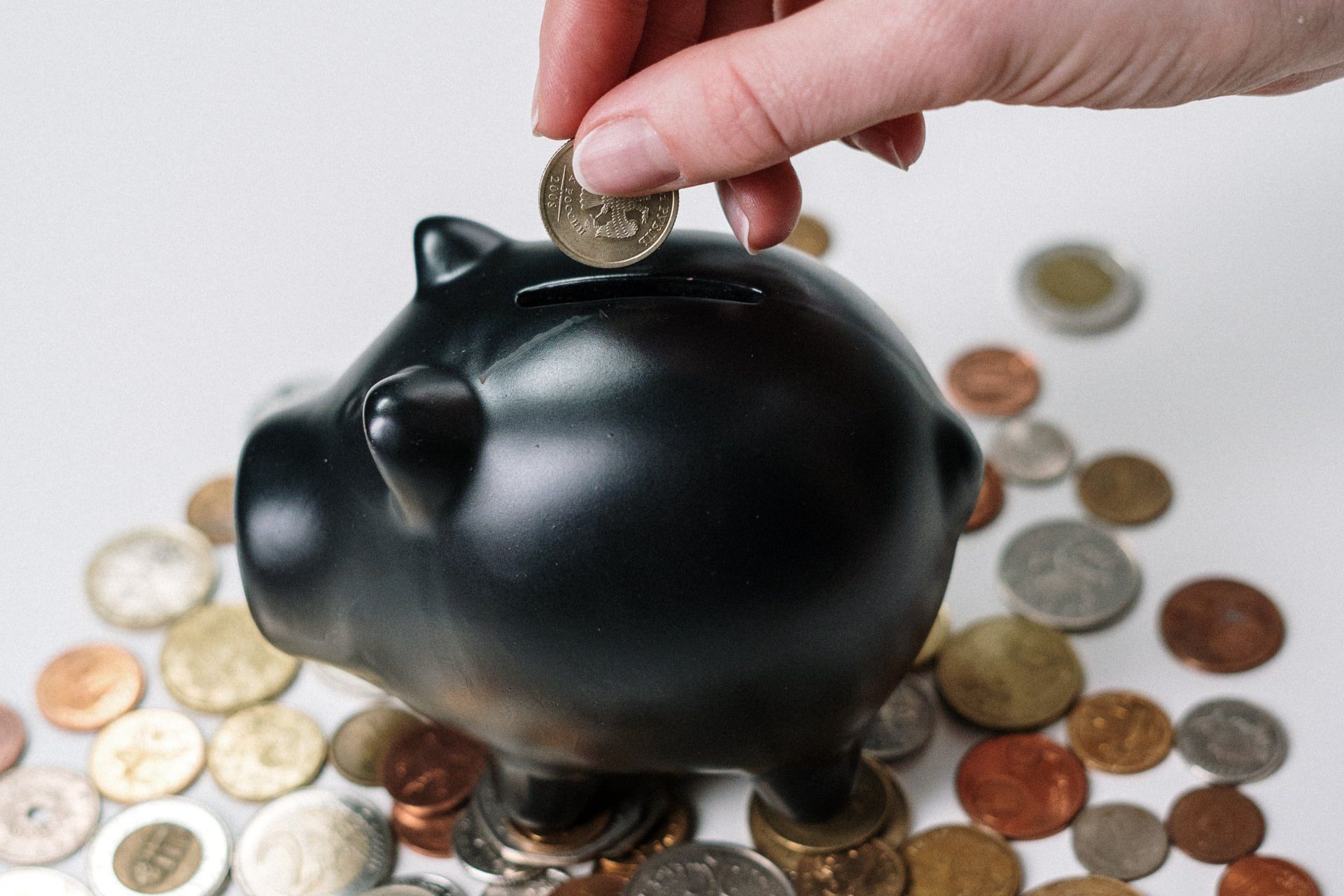 image of money being placed into piggy bank by a person