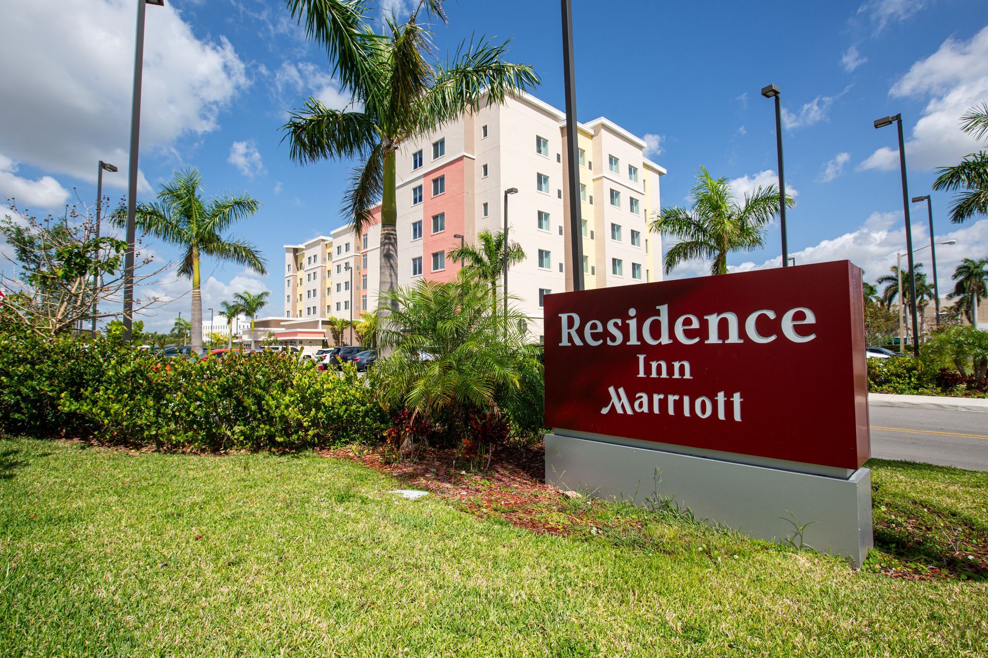 Residence Inn by Marriott sign with hotel building in the background on a sunny day.