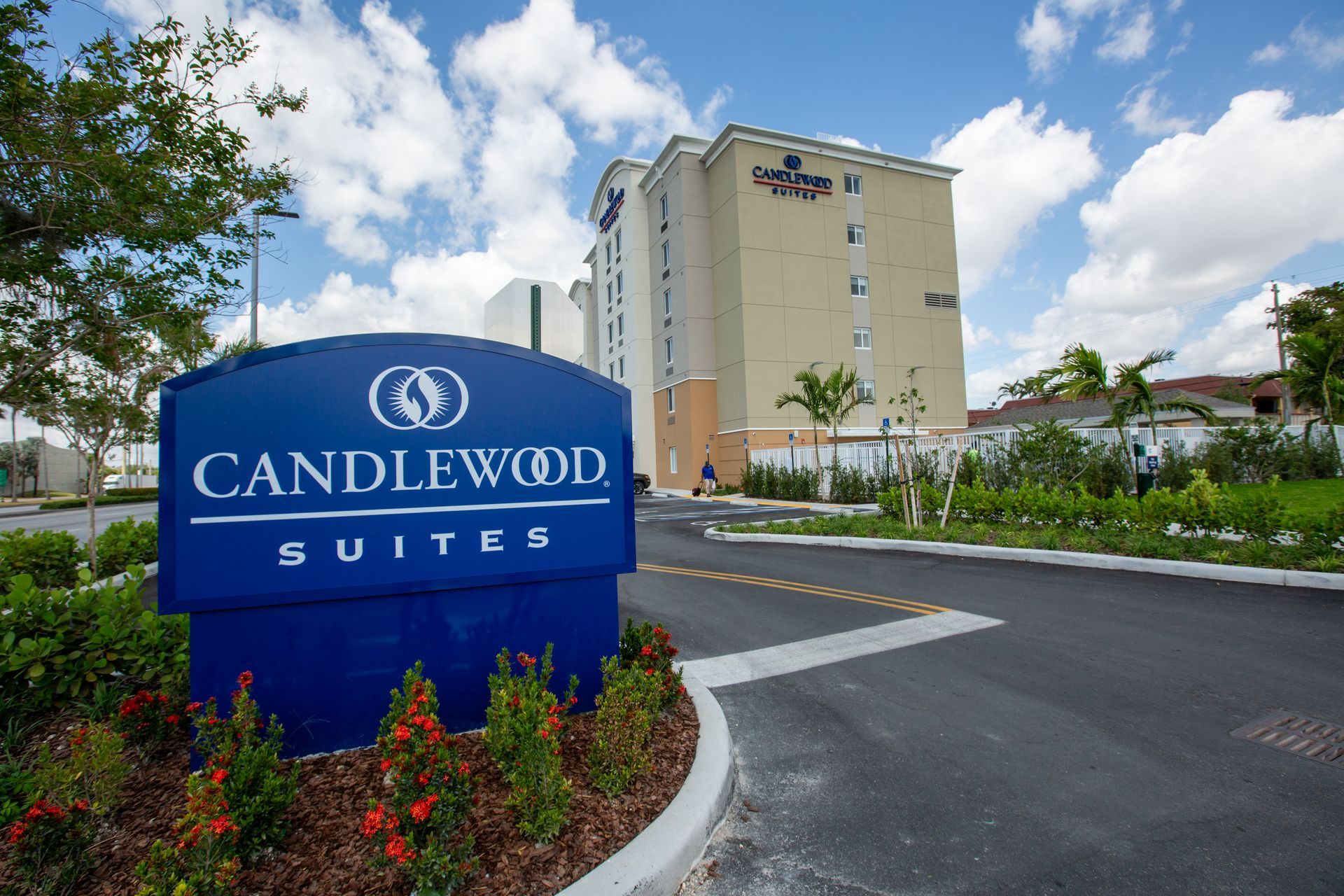 Candlewood Suites hotel sign in front of a multi-story building on a sunny day.