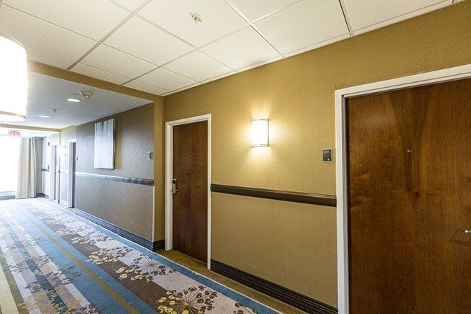 Hotel hallway with doors and floral patterned carpet.