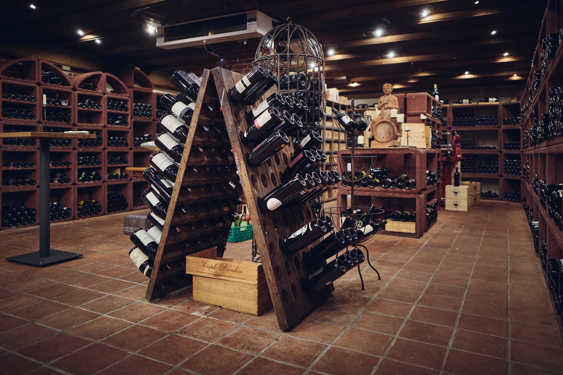 Wandmontierte Barregale mit verschiedenen Spirituosenflaschen und Glastüren sowie farbenfrohe Dekoration.