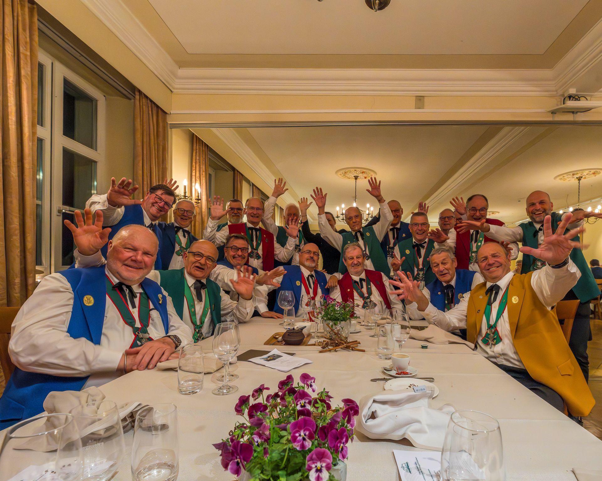 Eleganter Speisesaal mit gedeckten Tischen, braunen Stühlen und großen Fenstern mit Blick ins Grüne