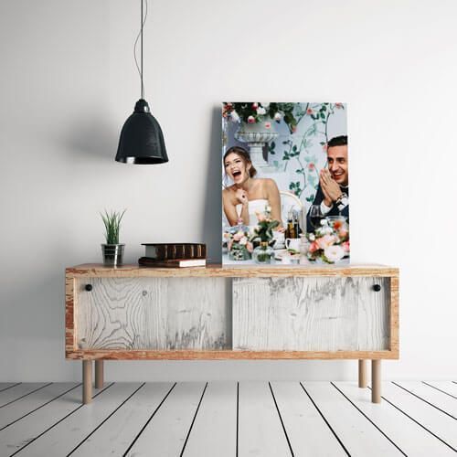 Modern wooden sideboard with lamp, plant, and framed wedding photo in a bright minimalist room