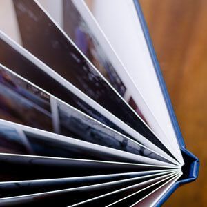 Close-up of a fan of glossy photo prints with a blue binding on the right