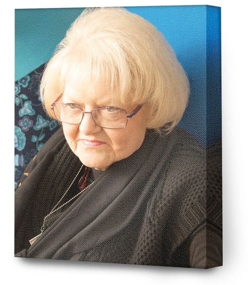 Portrait of a person with blond hair and glasses against a blue background