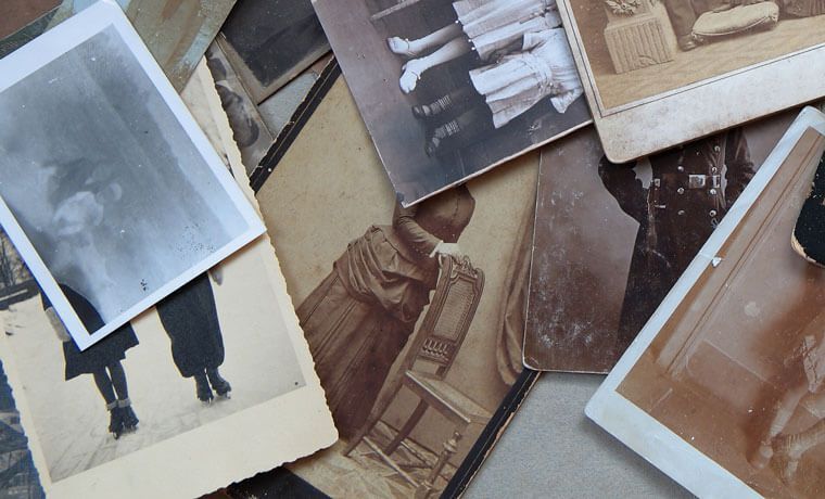 Scattered vintage sepia and black-and-white photos on a tabletop