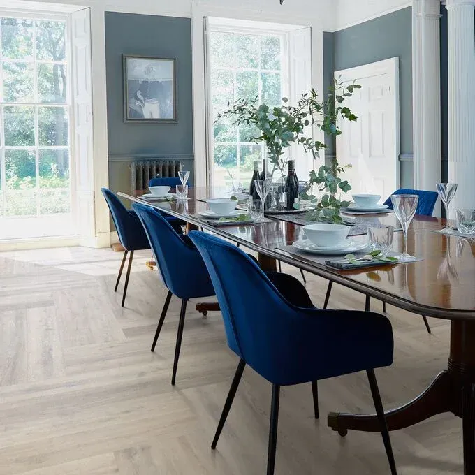 A dining room with a long table and blue chairs