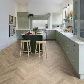 A kitchen with a herringbone floor and two stools.