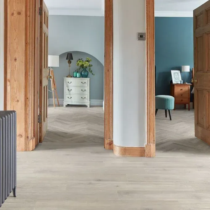 A living room with a wooden floor and a dresser.