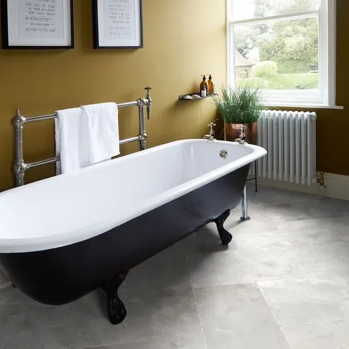 A bathtub in a bathroom with yellow walls