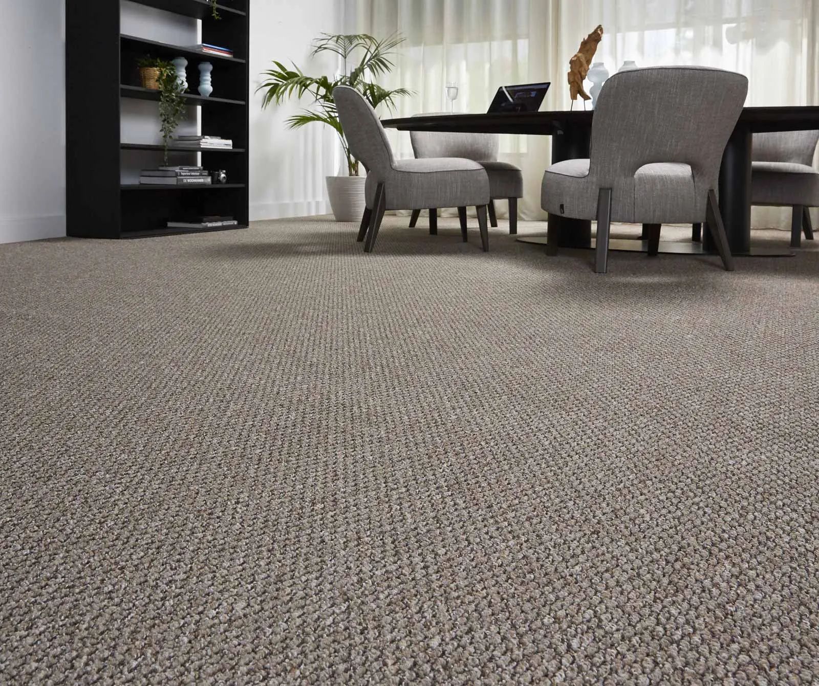 A dining room with a table and chairs and a carpeted floor