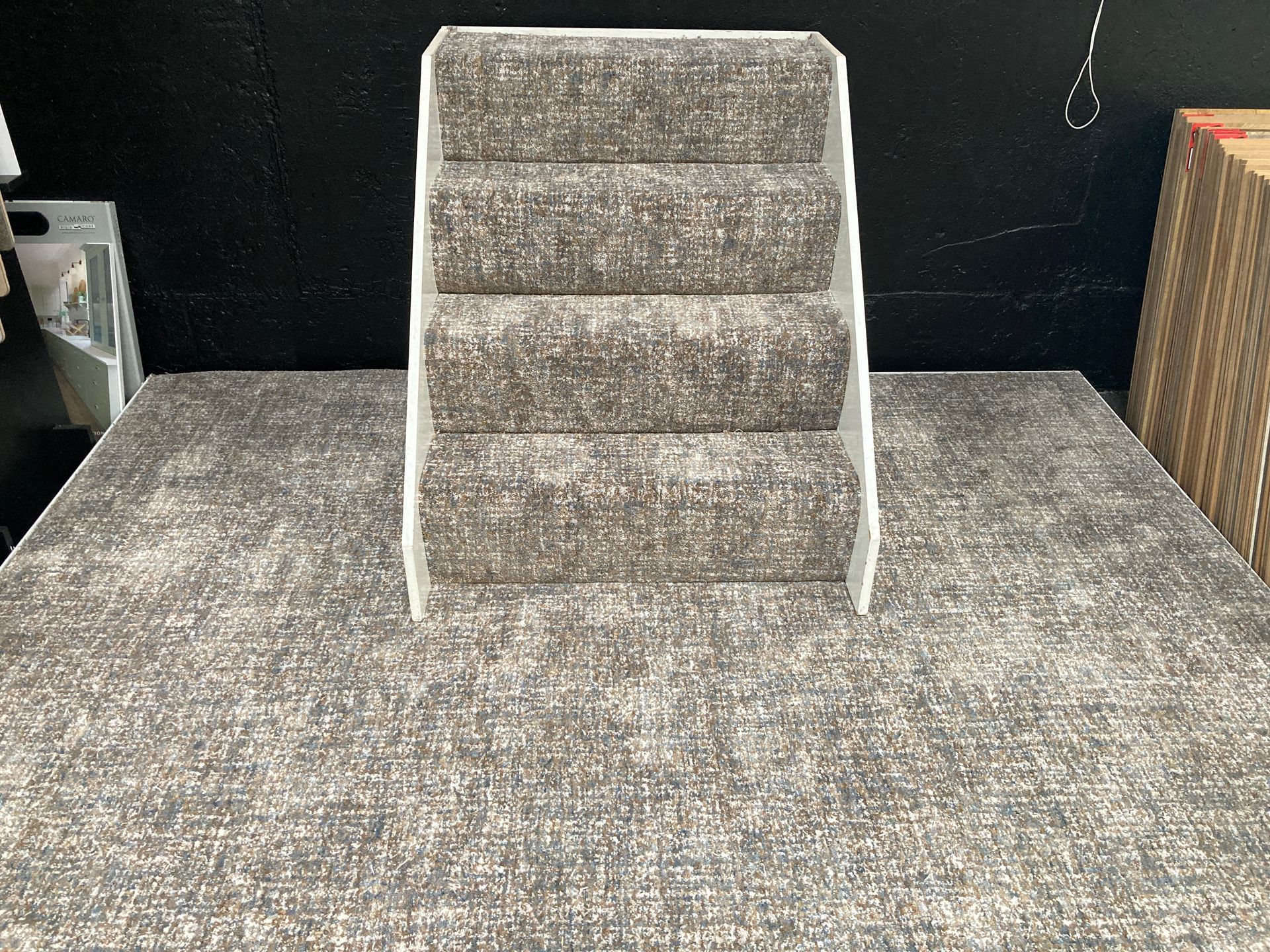 A small staircase is sitting on top of a carpeted table.