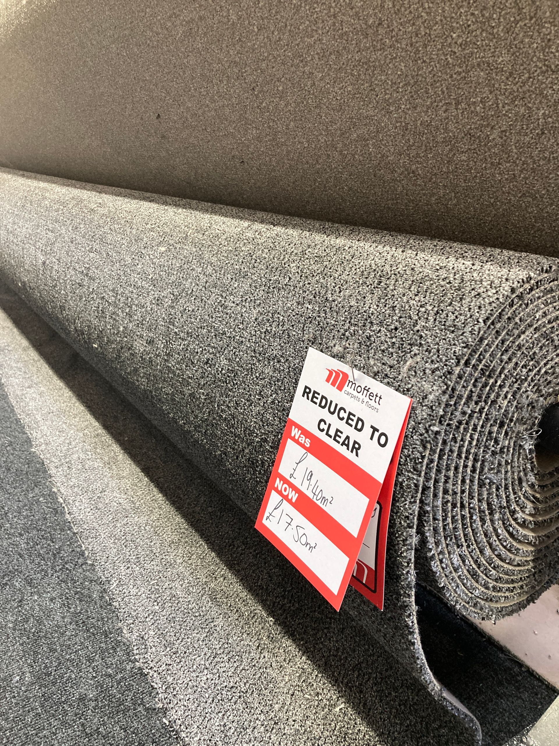 Rolls of gray speckled carpet with a 