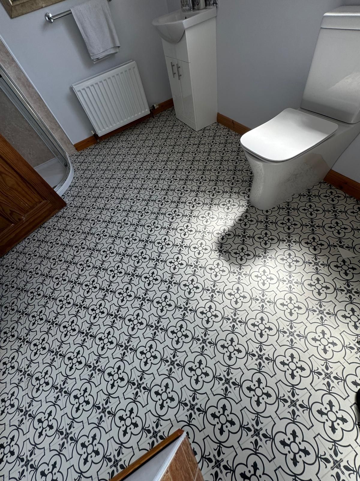 A bathroom with a toilet , sink and shower.