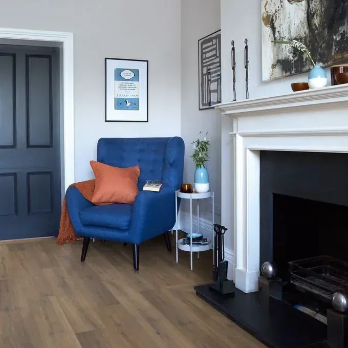A living room with a blue chair and a fireplace