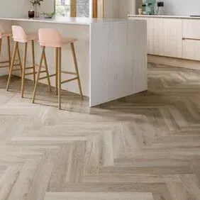A kitchen with a herringbone floor and stools.