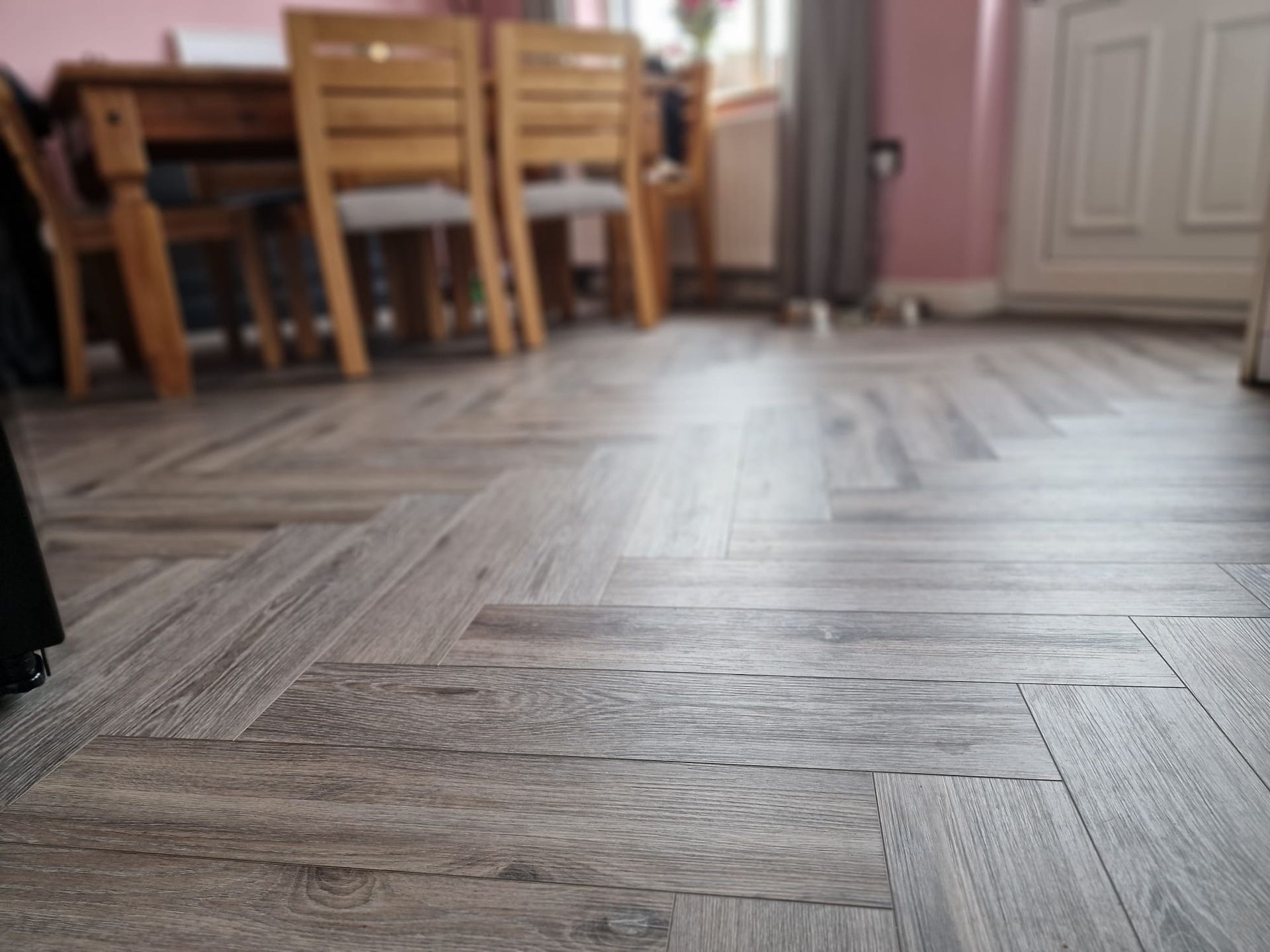 A wooden floor with a herringbone pattern in a room