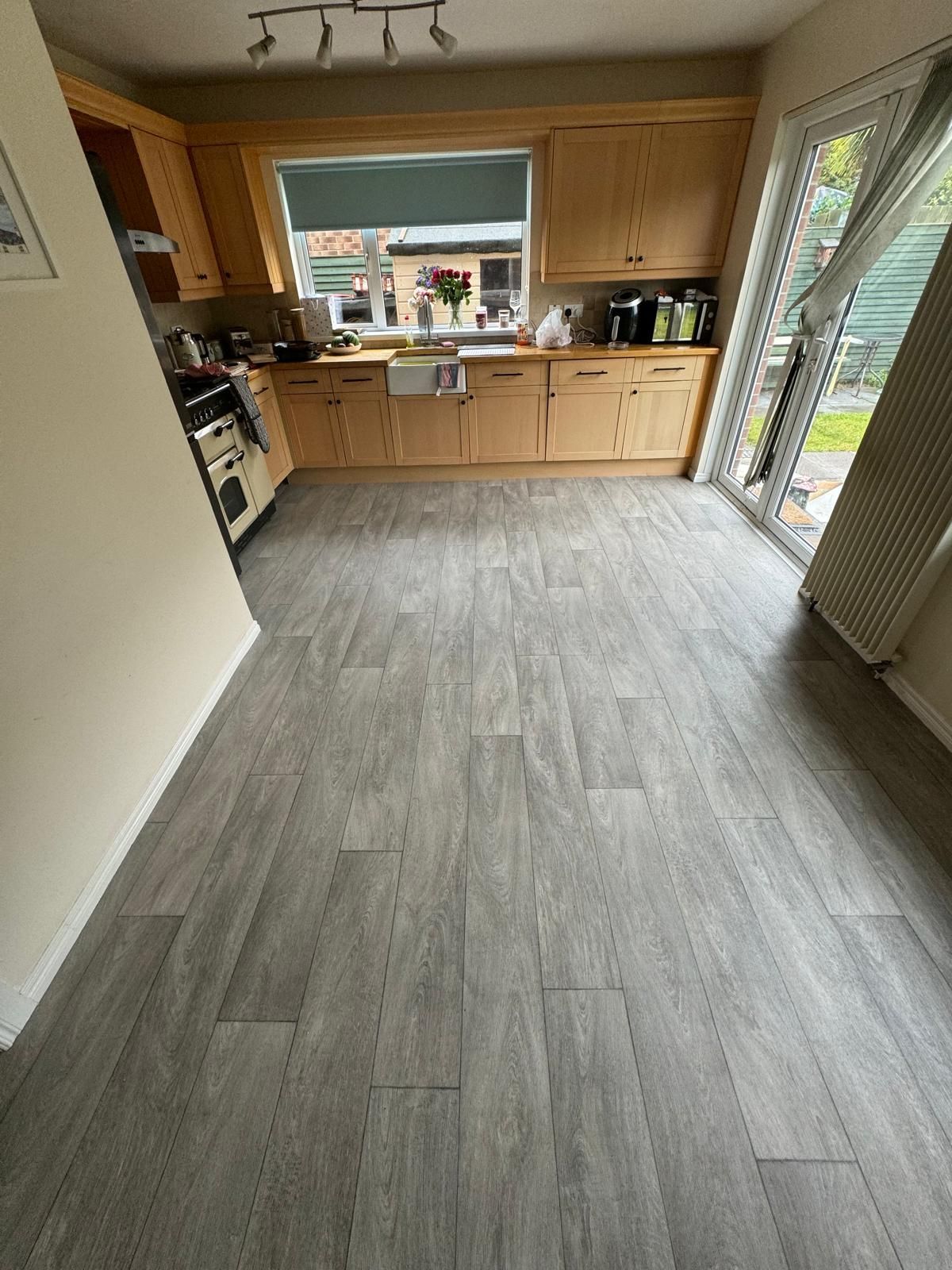 A kitchen with wooden cabinets and a gray floor.