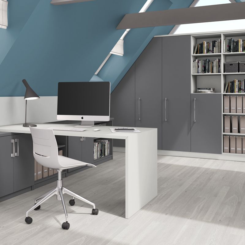 A white desk with a computer and chair in a modern home office with blue walls and grey storage cabinets.