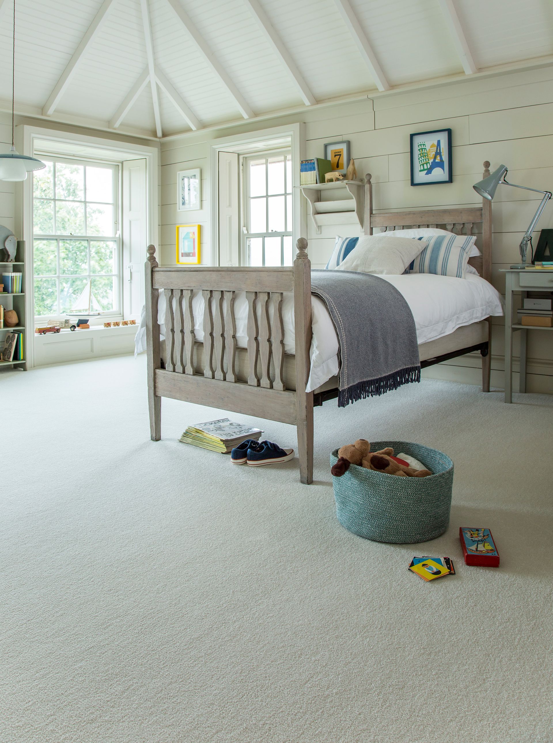 A bedroom with a bed , desk , and window.