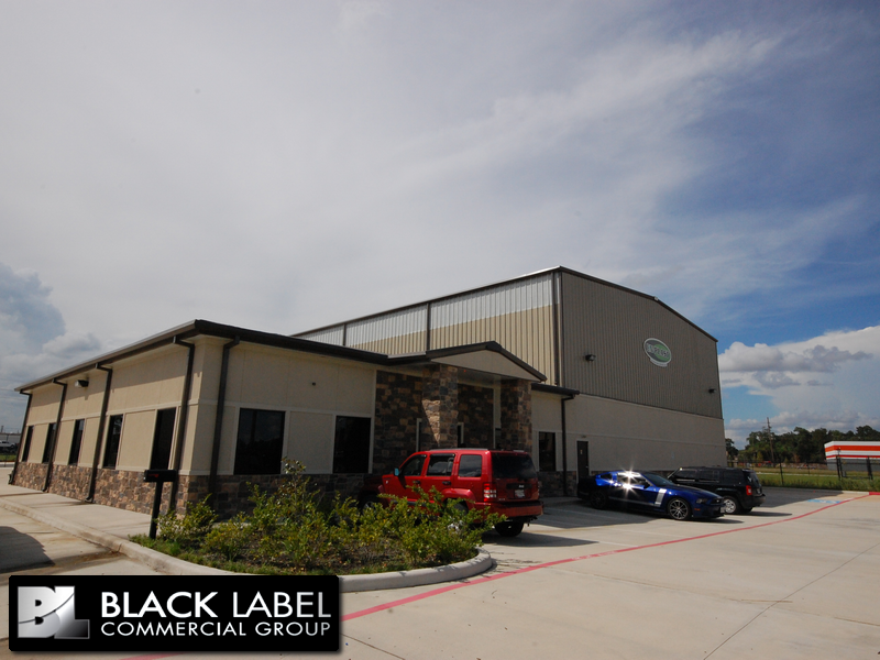 A red truck is parked in front of a building that says black label commercial group