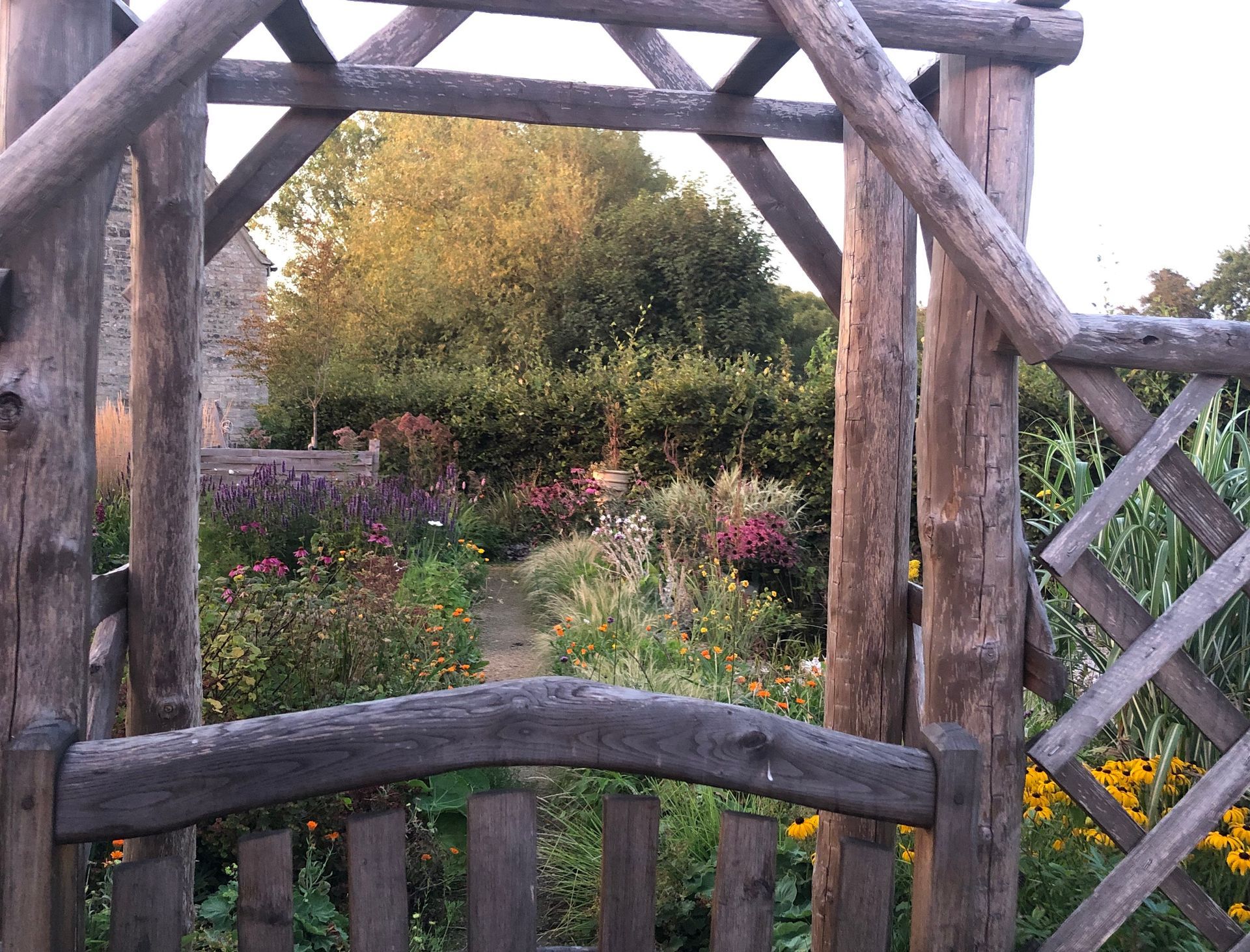 garden planting design, wildlife-friendly, cotswold, cottage, chestnut trellis fence, arch, naturalistic, path, gate, rustic