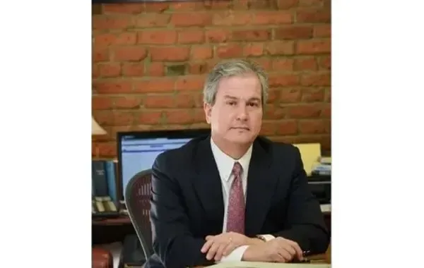 A man in a suit and tie is sitting at a desk.