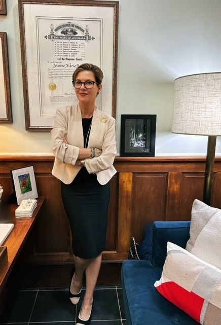 A woman is standing in a room with her arms crossed.
