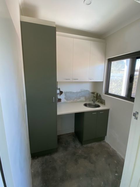 A kitchen with a sink , cabinets and a window