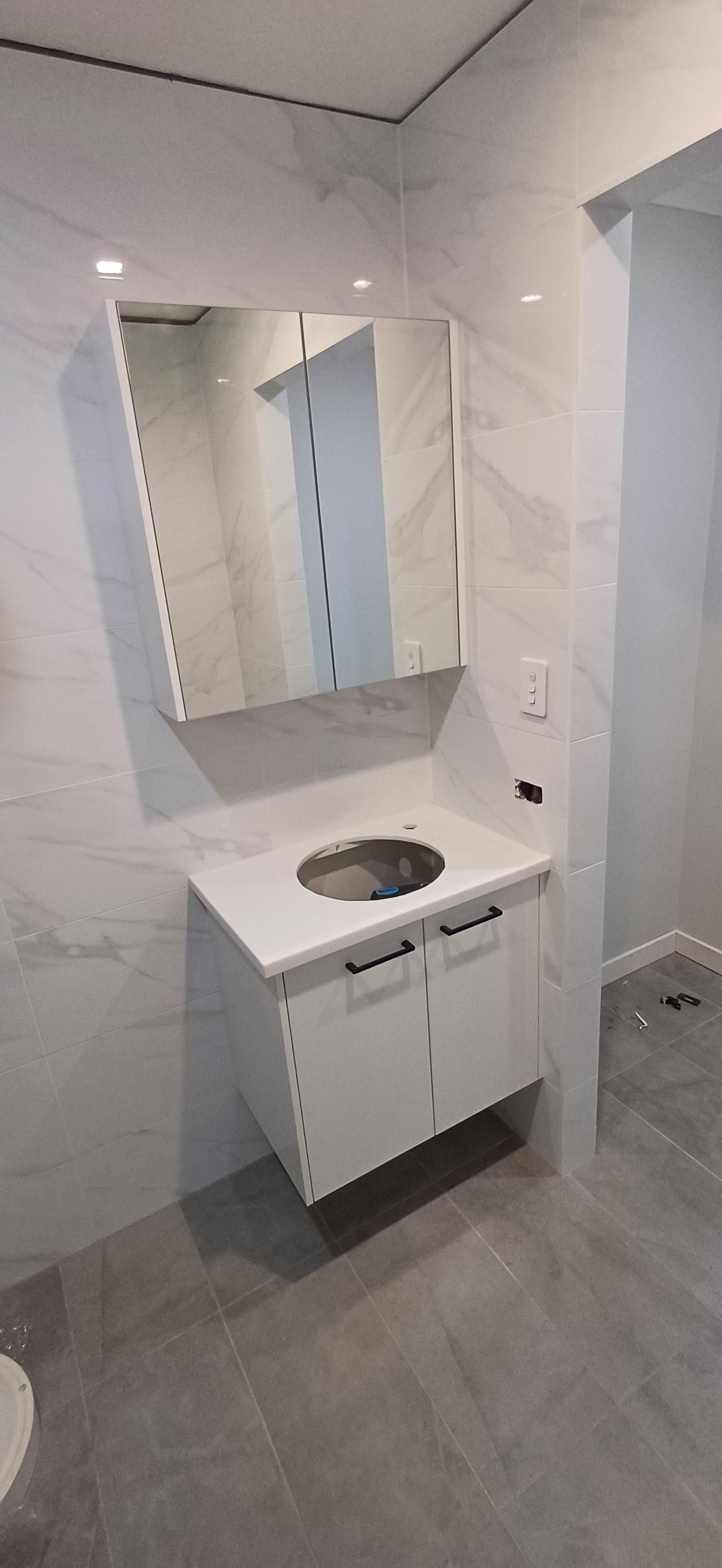 A bathroom with a sink , mirror and toilet.