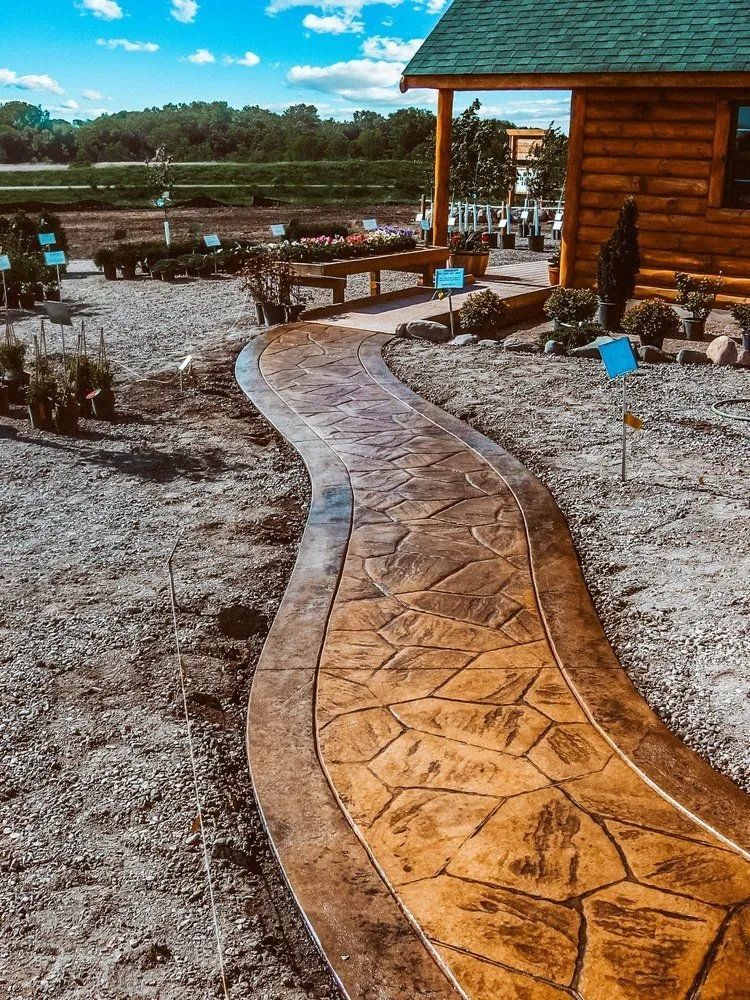 Stamped concrete walkway with a stone pattern, winding through a garden area.