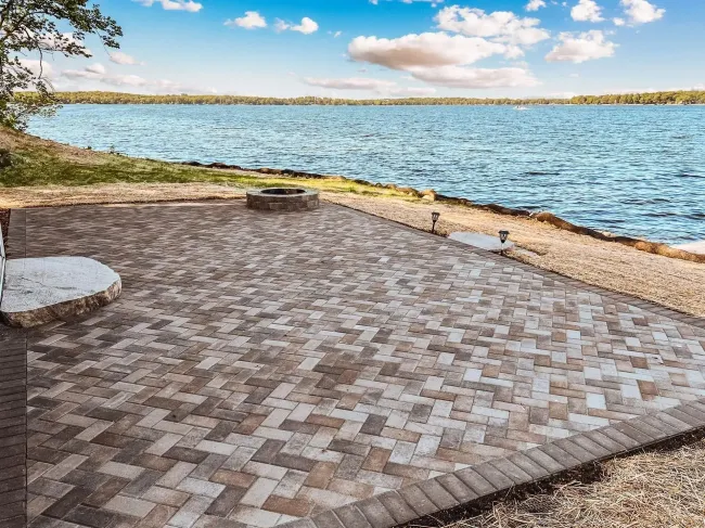Patio furniture and grill sitting on top of a dark gray patio concrete stamping.