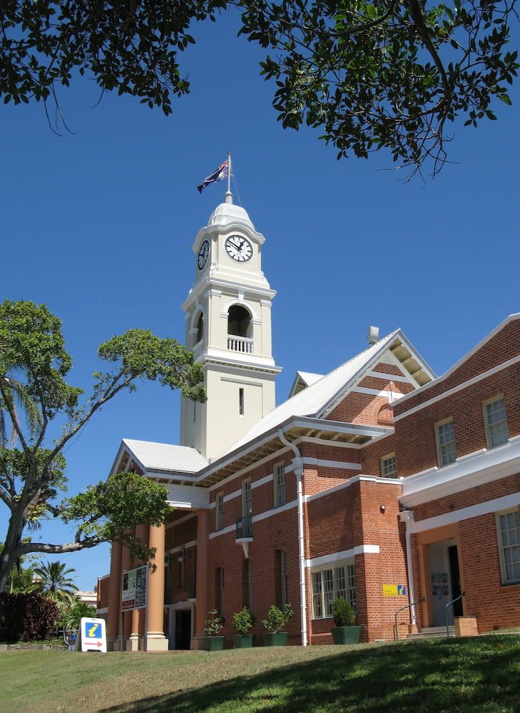 A Large Brick Building With a Clock Tower on Top of It — Bargara Removals in Maryborough, QLD