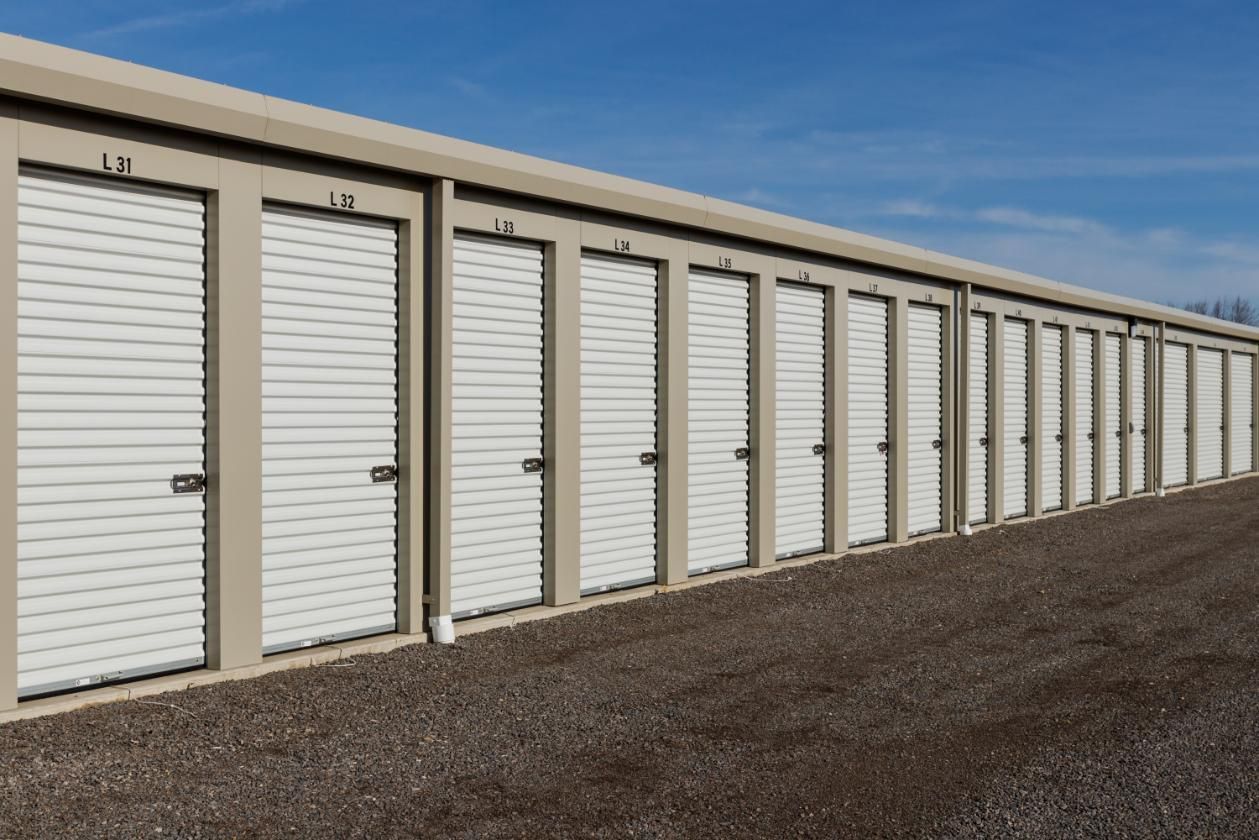 Row of Storage Units With White Doors on a Gravel Road — Bargara Removals in Gympie, QLD