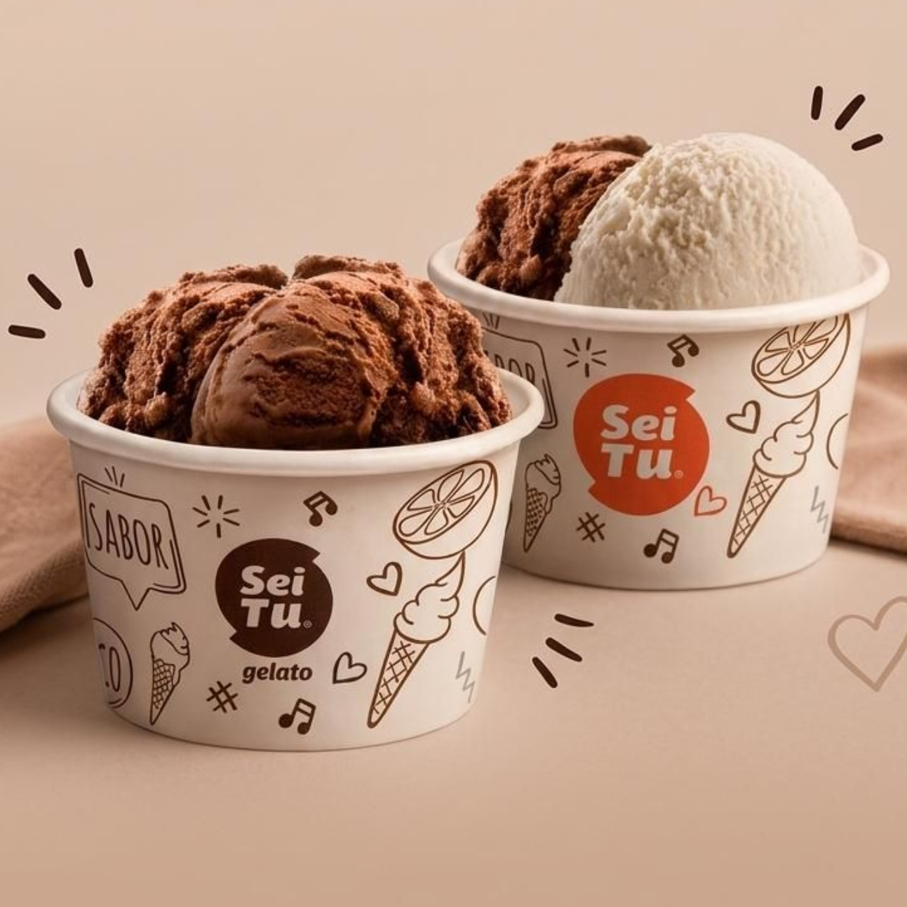 Dos tarrinas de helado con bolas de chocolate y vainilla sobre una superficie beige, decoradas con divertidos garabatos.