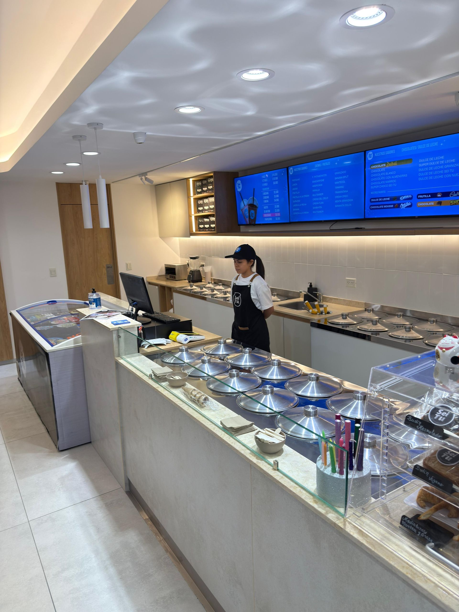 Mostrador de buffet moderno en un restaurante luminoso con pizarras de menú azules iluminadas .