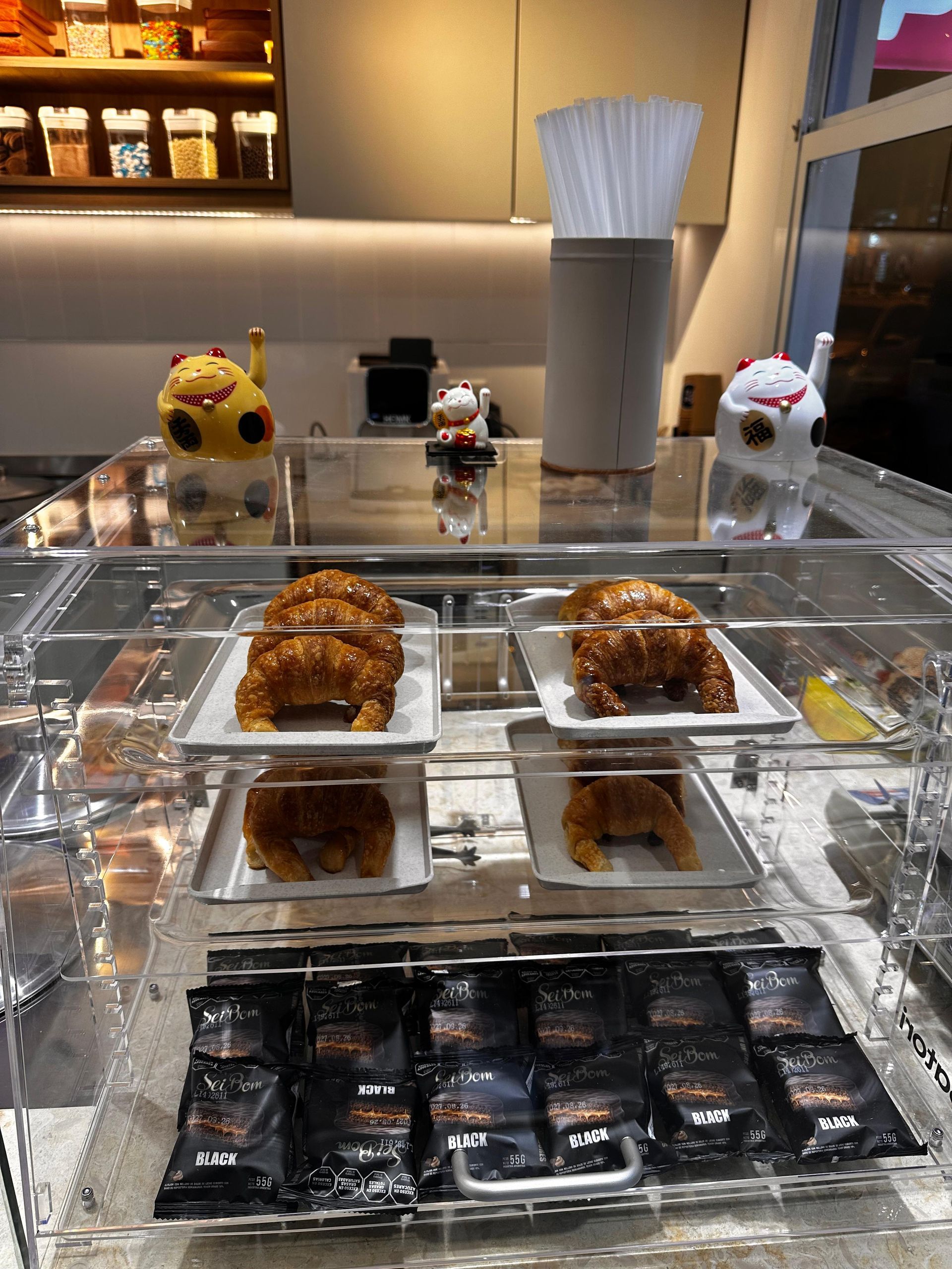 Vitrina de panadería con pasteles variados y pequeñas decoraciones con forma de animales en la parte superior.