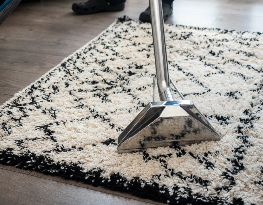 Chrome-legged chair on a cream-and-black patterned rug over a wood floor.