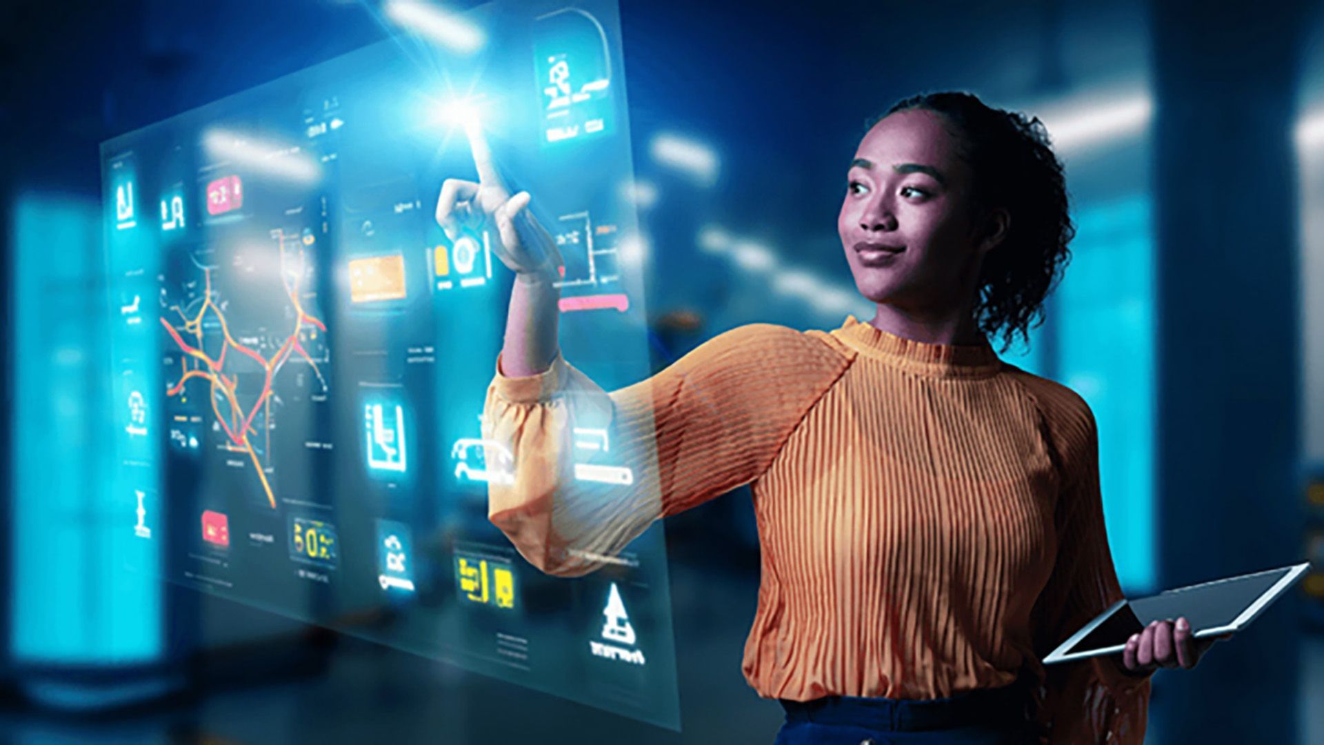 A woman is holding a tablet and pointing at a futuristic screen.