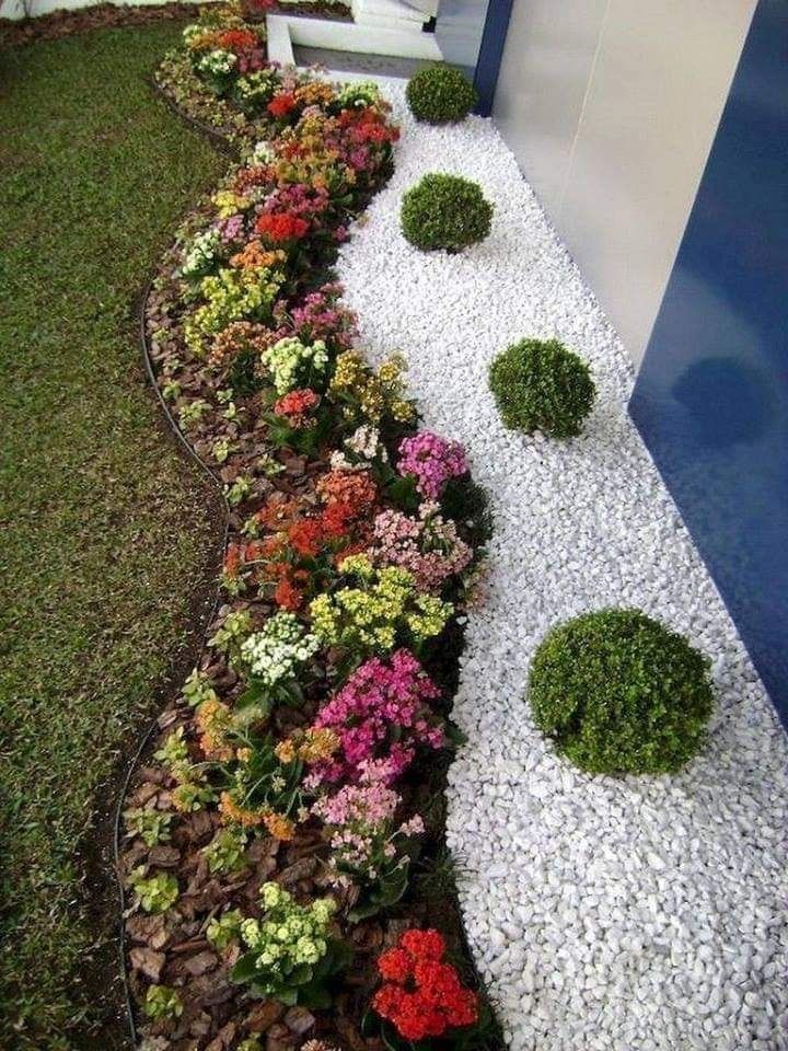 Camera moderna con ampie finestre che si affacciano sul verde paesaggio. Piante e opere d'arte decorano l'ambiente.