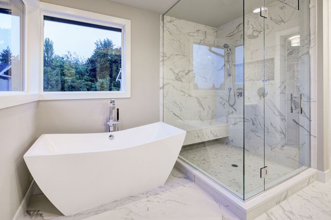 A bathroom with a bathtub and a walk in shower.