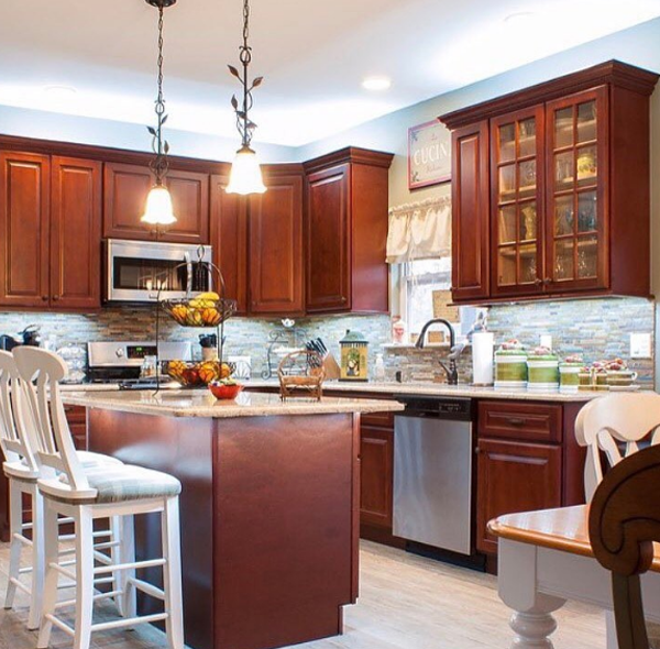 Kitchen with mahogany cabinets, granite countertops, island with seating, stainless steel appliances.