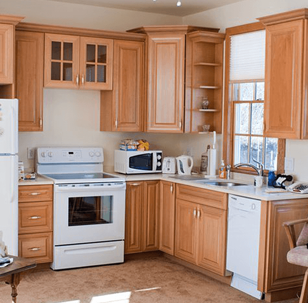 Kitchen with light-colored wooden cabinets, white appliances, and a window above the sink.