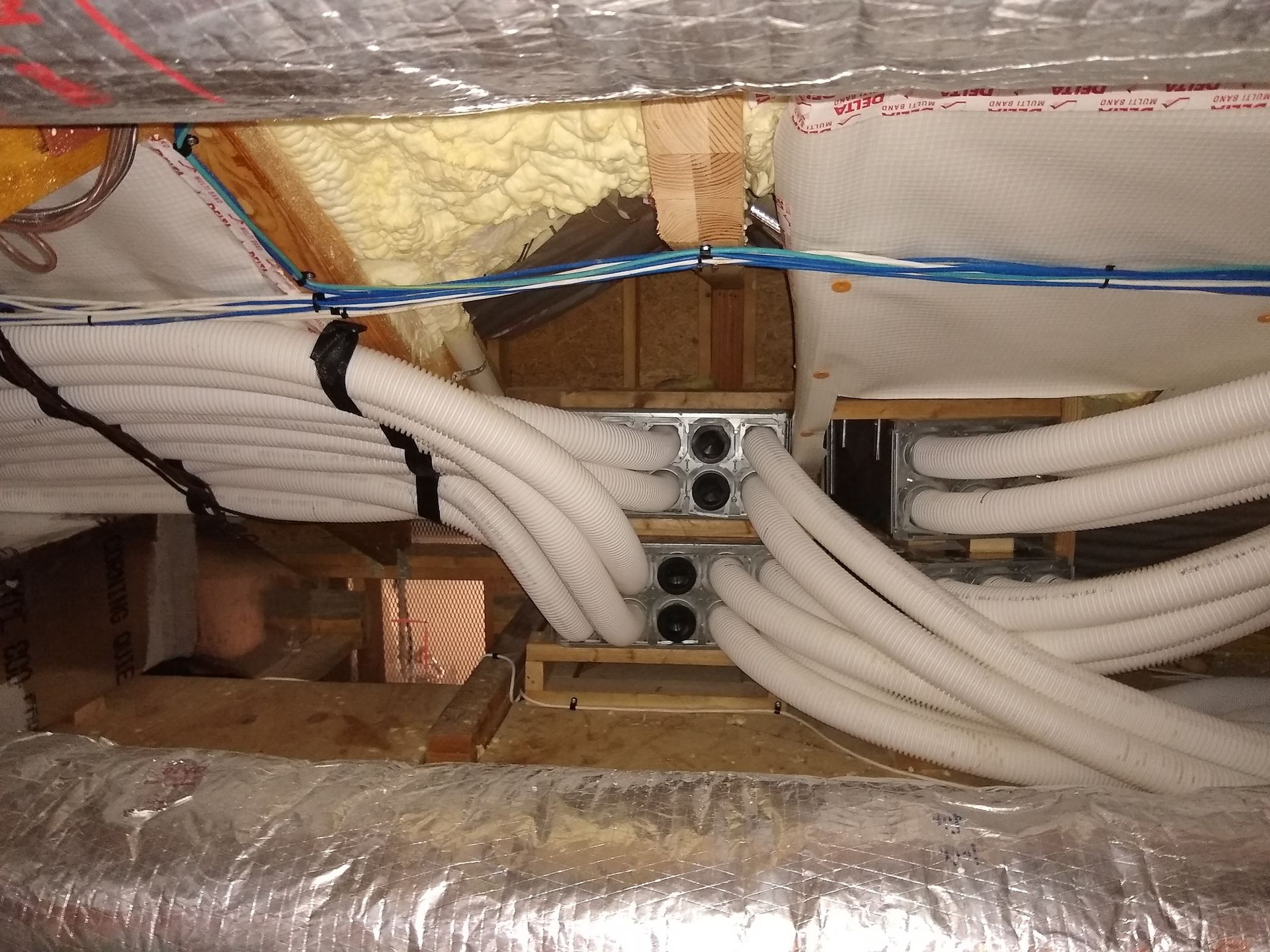 A bunch of white pipes are hanging from the ceiling of a building